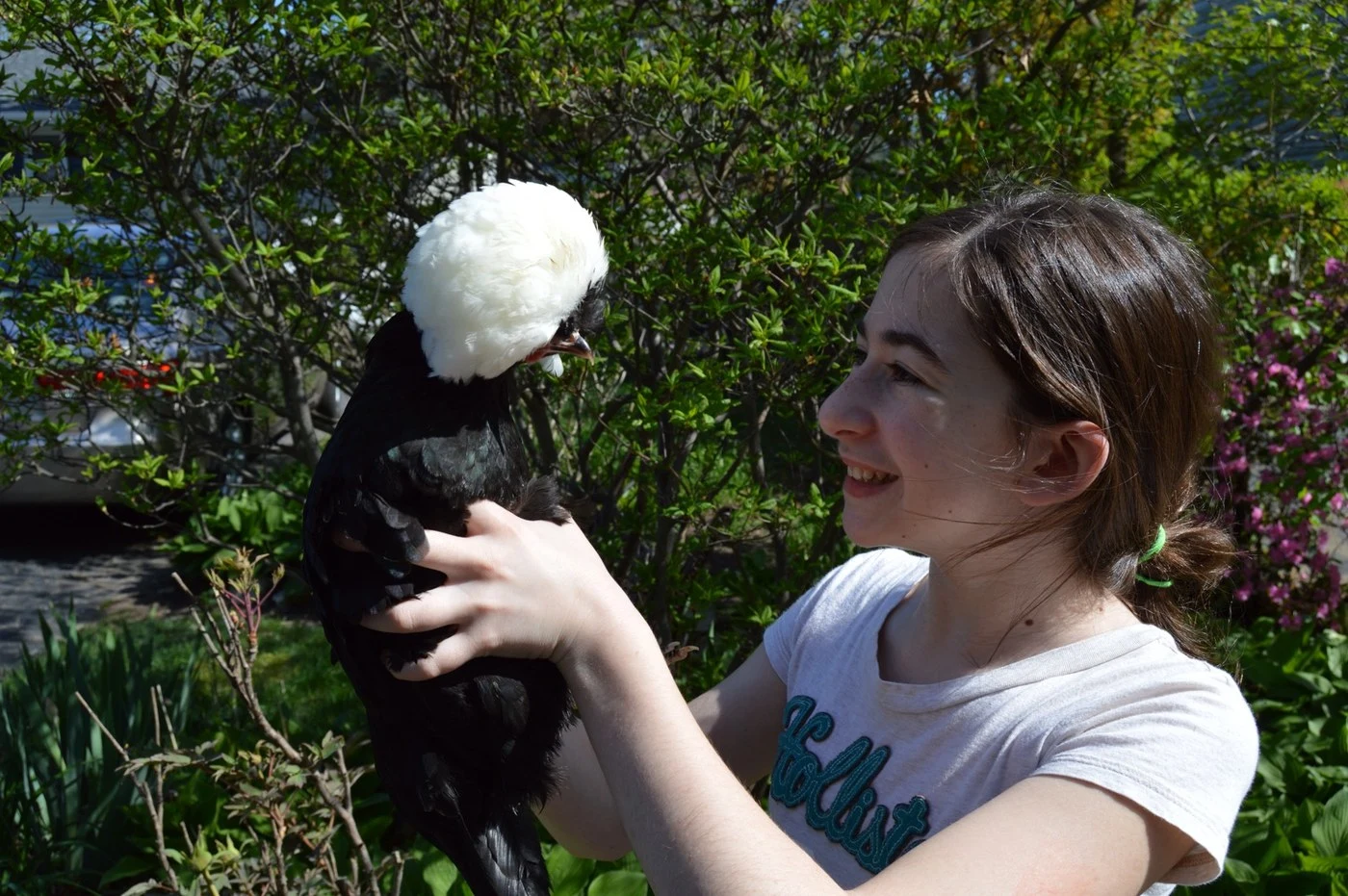 Victoria smiling with a black and white crested chicken